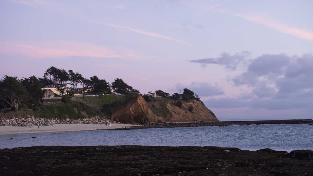 King Tide tide pooling in Half Moon Bay - cliff against the sea with houses atop