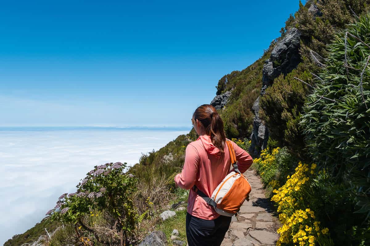 Hiker on the trail above the clouds near Pico Ruivo