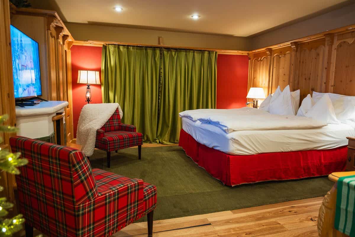 Cozy bedroom suite at Abendblume in Leavenworth with red plaid armchairs and a canopy bed