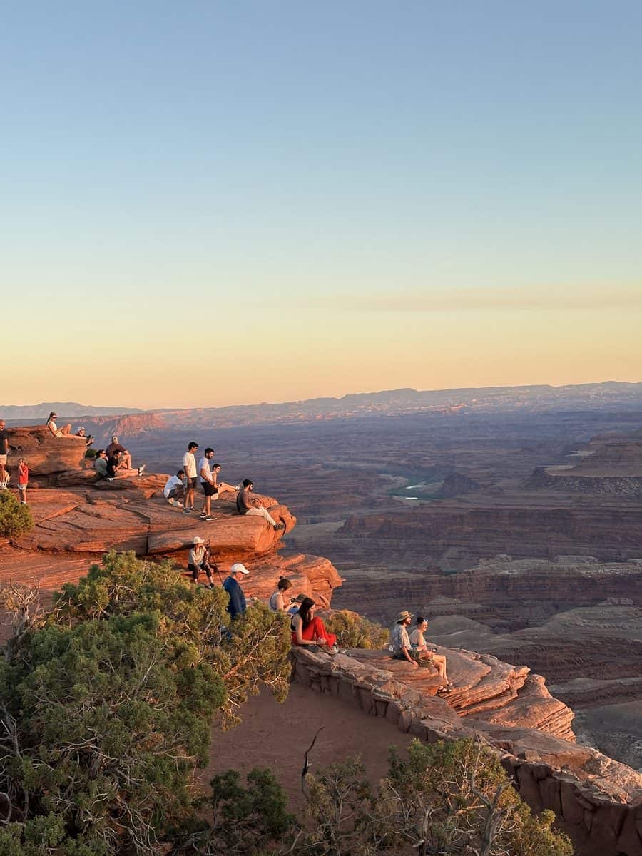 Sunset at Dead Horse Point State Park with visitors watching the canyon