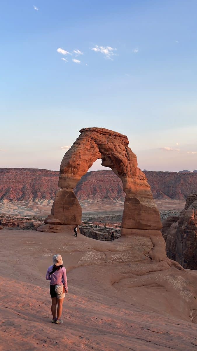 Hiker on the trail approaching Delicate Arch in Arches National Park