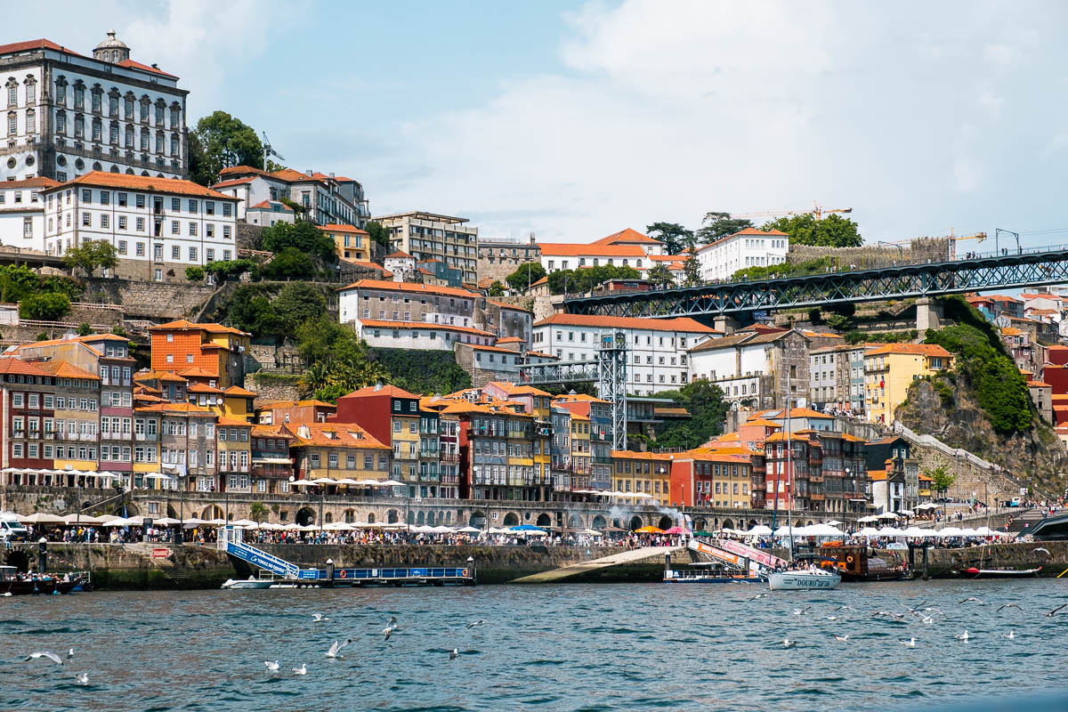Colorful Ribeira facades seen from a Six Bridges cruise boat on the Douro