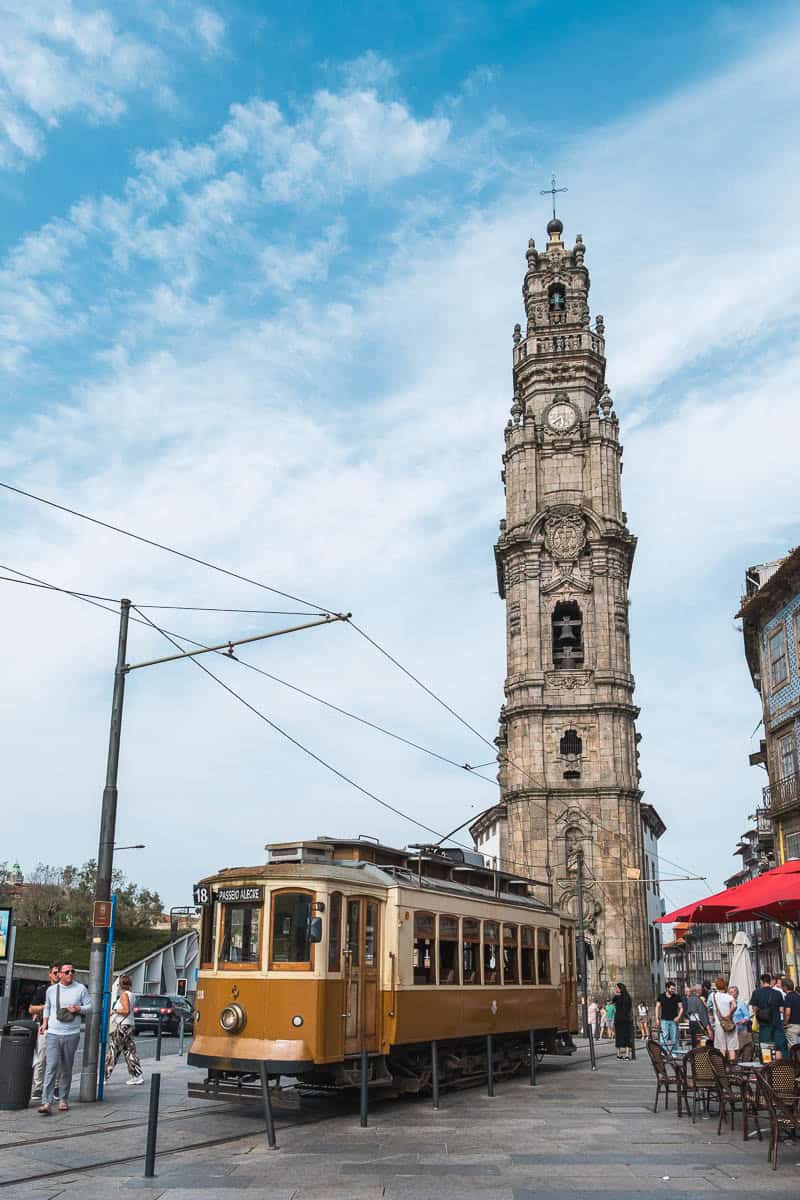 Torre dos Clerigos with a yellow historic tram passing in front